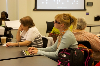 Jen sitting and typing at a MABVI Support Group Coordinator Training in 2014